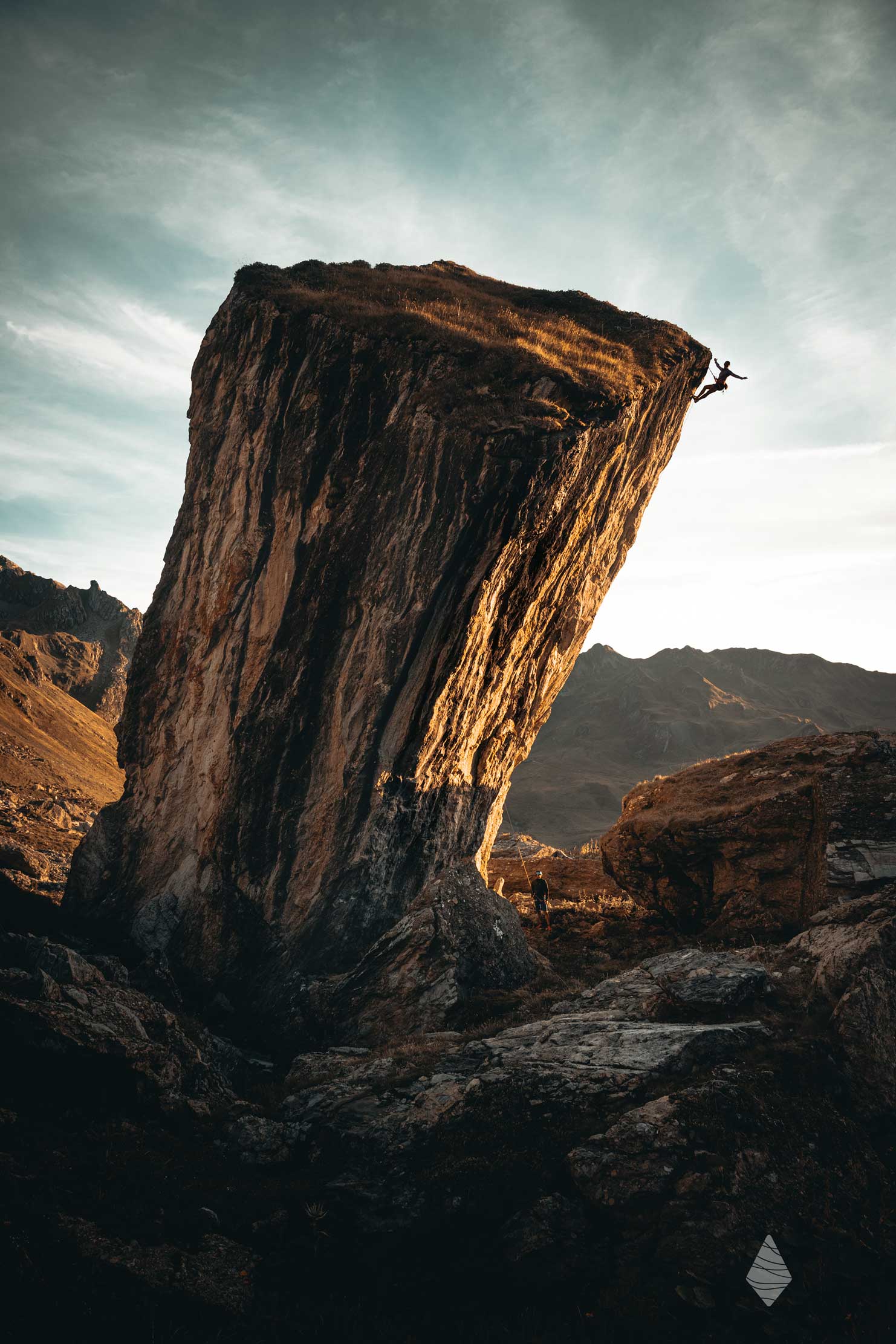 Photo du bloc monolithe avec un grimpeur au sommet