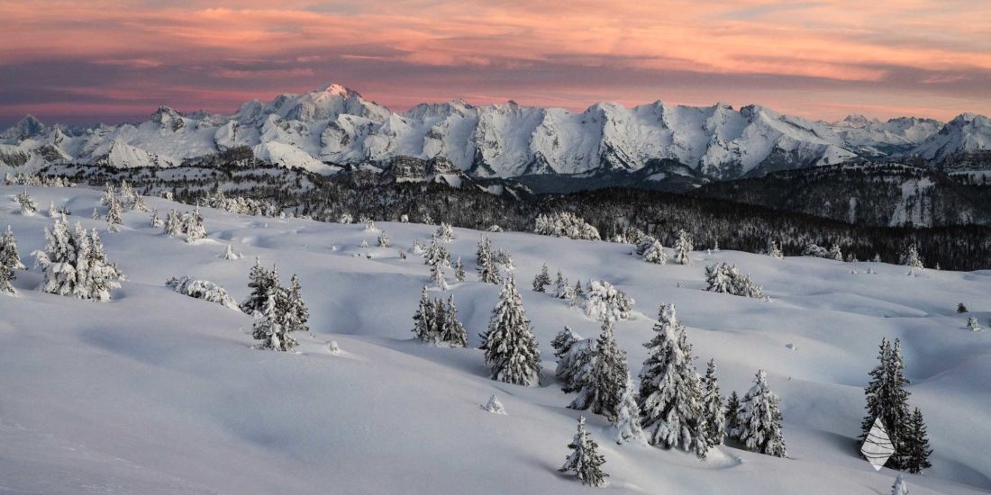 Photo panoramique de la chaîne des Aravis et du Mont Blanc en hivers avec les couleurs du crépuscule